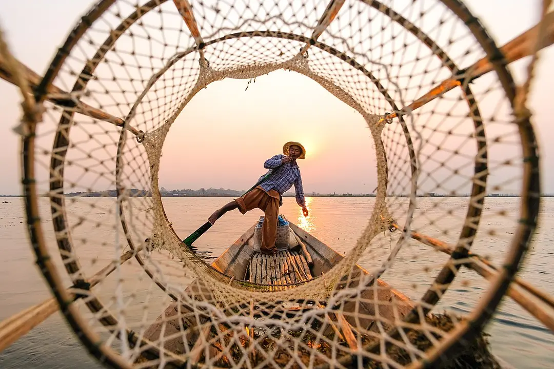 用脚划船的缅甸渔夫
